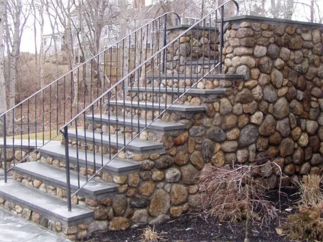 Fieldstone stairway with bluestone treads and an iron railing