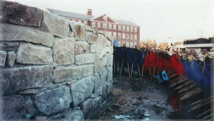 Stone seawall under construction behind a sediment barrier